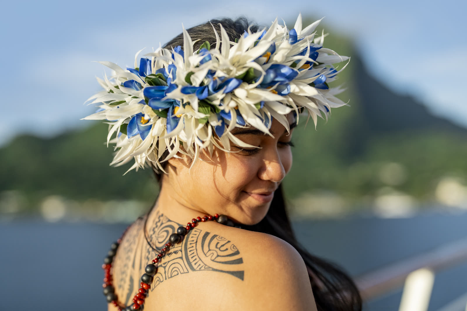 A Tahitian host in a flower crown and traditional tattoo aboard the ship